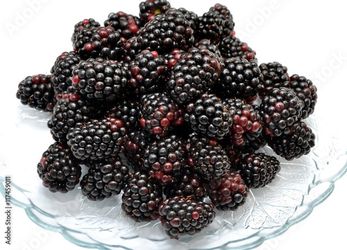  The photo shows a dish with dewberry on a white background