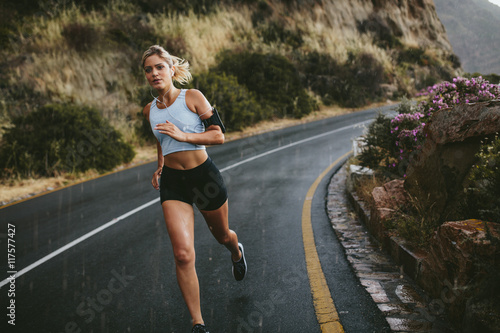 Female athlete running along the highway