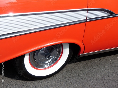 Weißwandreifen und Chromschmuck einer roten amerikanischen Limousine der Fünfziger Jahre bei Sonnenschein beim Oldtimertreffen Golden Oldies in Wettenberg Krofdorf-Gleiberg bei Gießen in Hessen