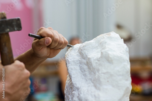 Man carving stone statue