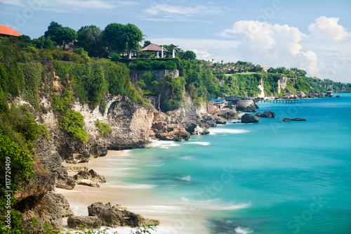 Scenic landscape of high cliff on tropical white sand Pantai beach in Bali, Indonesia