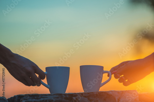 Friends drinking coffee in sunset / sunrise. Shallow depth of field.