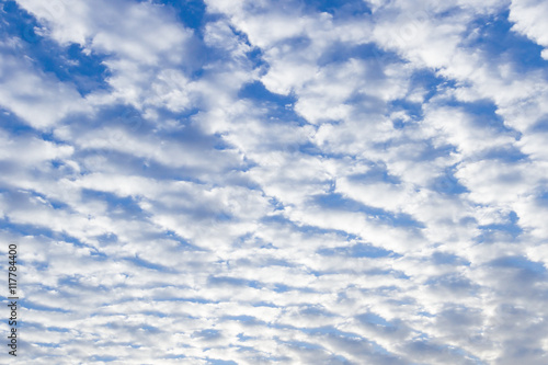 White puffy stratus clouds against a deep blue sky.