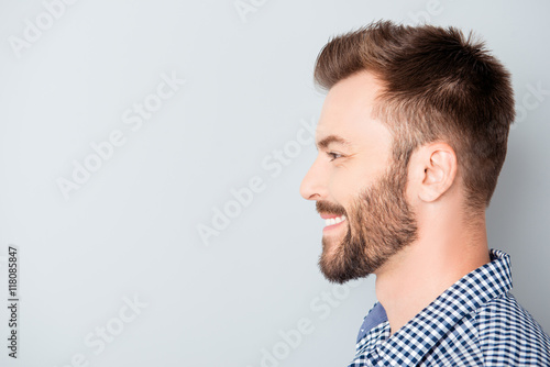 Side view of young happy smiling bearded man