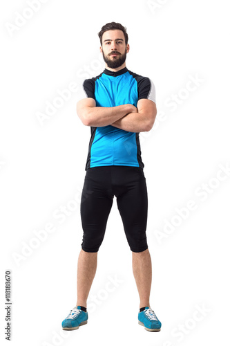 Muscular fit sportsman cyclist in sportswear with crossed arms looking at camera. Full body length portrait isolated over white studio background.
