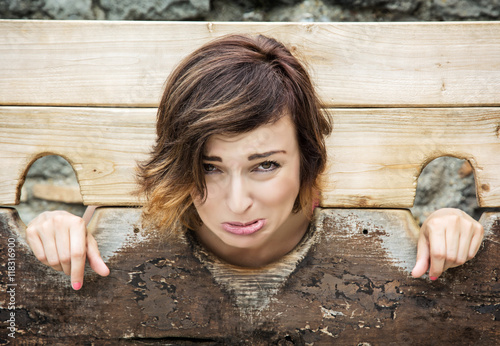 Young caucasian woman in medieval pillory