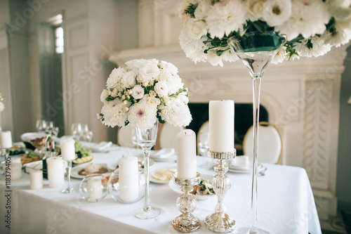 Table decor with white flowers and candles for an event party or wedding reception
