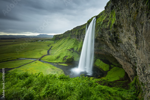 gray day above the waterfall and green valley in Iceland