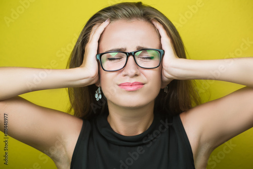 Young tired female office worker suffering headache