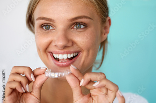 Smiling Woman With Beautiful Smile Using Teeth Whitening Tray. High Resolution Image