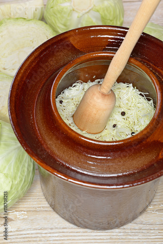 Kraut stampfen im Krauttopf für die Herstellung von Sauerkraut - Food fermentation, making sauerkraut: White cabbage with a tamper in a fermentation crock 