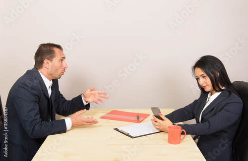 Woman looking at the smartphone and ignoring her companion