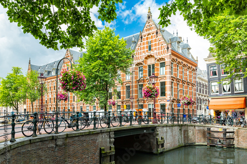 Typical canal side cityscape of Amsterdam, opposite from the 17th century HQ of the Dutch East India Company, now used by the University of Amsterdam