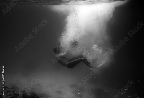 Diver plummet into black ocean with sunlight bubble,black and wh