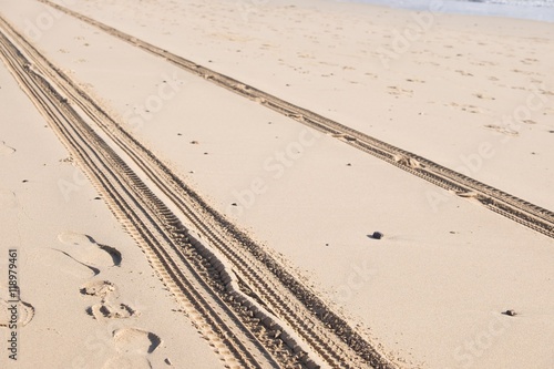 car track on sand in desert