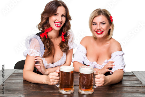 Two beautiful blond and brunette girls of oktoberfest beer stein