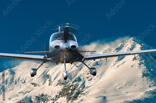 Privat plane or aircraft flight above winter mountains
