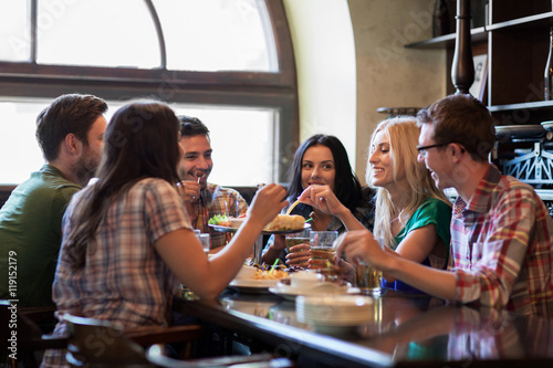 happy friends with beer eating at bar or pub