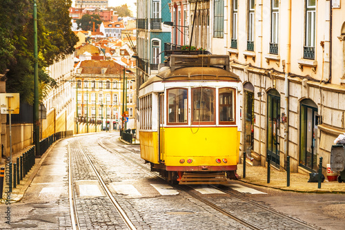 Klasyczny żółty tramwaj na ulicy w Lizbonie, Portugalia