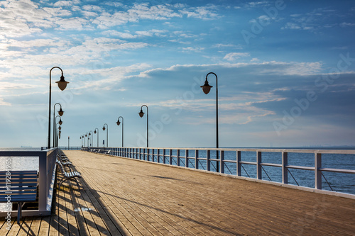 Wooden pier with benches and lanterns in the morning. Gdynia-Orlowo. Poland.