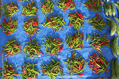 Kupki czerwonej i zielonej papryczki chili na niebieskim tle na bazarze ulicznym