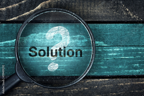 Solution text painted and magnifying glass on table