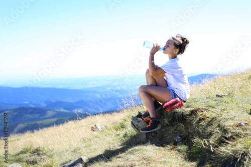  Letnie wakacje w górach Dziewczynka pije wodę. 