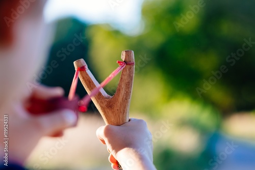 Little boy playing with slingshot