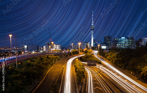 City skyline with traffic on highway and star trails on sky, Auckland