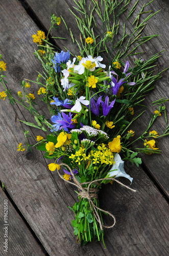 bunch of bells on a wooden background, wild flowers tied with a linen rope, flowers for the bride, place for your text, invitation card,