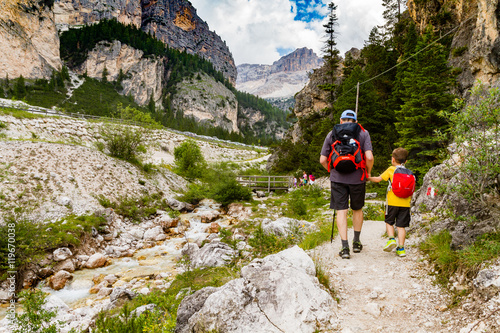 Dolomites Italy, father and son walking along a mountain path
