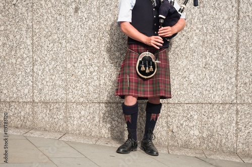 bagpiper dressed in kilt playing bag pipes