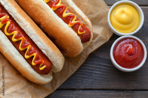 Barbecue Grilled Hot Dog with Yellow Mustard and ketchup on wooden table. Fast food.