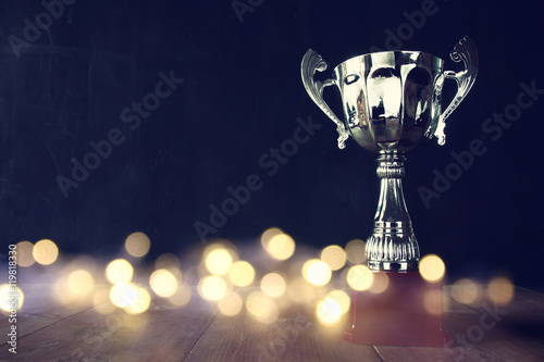 low key image of trophy over wooden table