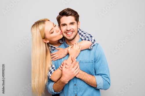 Young woman huging and kissing her handsome smiling husband