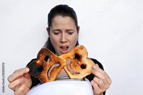 Shock woman looks a two different slices of toast
