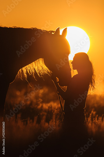 Girl and horse silhouette at sunset 