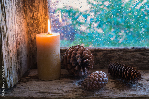 lit candle and pine cones