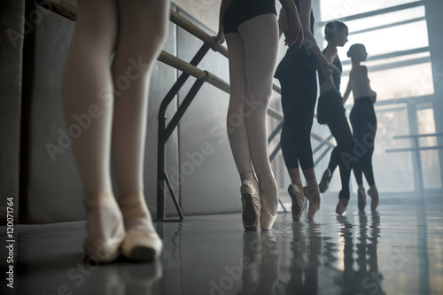 Dancers stands by the ballet barre.