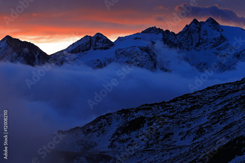 Twilight in the mountain. Foggy morning in Italian Alps, early morning in the mountain with snow during violet twilight, hills in the clouds. Snow in the mountain, Alp, Gran Paradiso, Italy