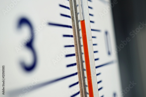 Macro detail of and old dusty outdoor thermometer in the retro design measuring very high temperature of thirty five degrees of Celsius as a symbol of summer and heat 