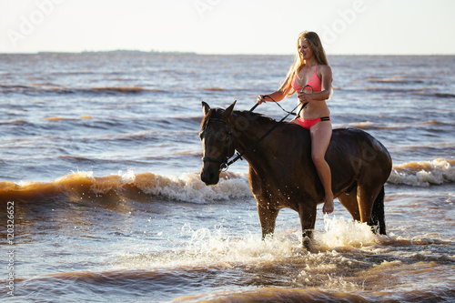 Woman dressed bikini ride horse in the water river