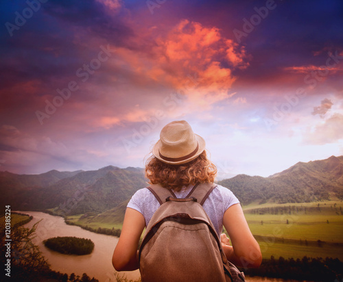 Young woman traveler standing with her back against the backgrou