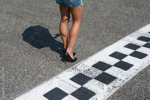 Woman sexy legs on motorsport asphalt track