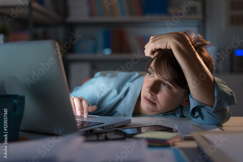 Sleepy woman working with her laptop