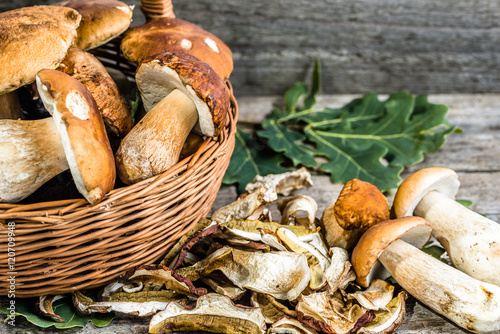 Dry mushrooms and harvested boletus mushroom in a basket on rust
