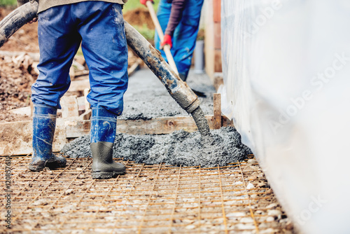 Constuction details - worker laying cement or concrete with automatic pump