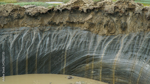 YAMAL PENINSULA, RUSSIA - JUNE 18, 2015: Expedition to the giant funnel of unknown origin. The crater wall from the permafrost.