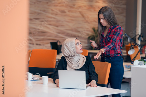 Worried arabic businesswoman wearing hijab receiving a notification from a colleague in her workplace at office