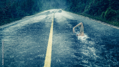 Mann schwimmt auf regennasser Fahrbahn